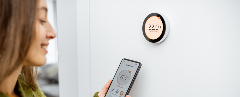 Immobilienverwalterin prüft Thermostat für hydraulischen Abgleich