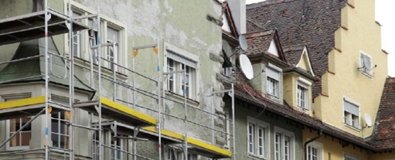 Symbolbild für Bausubstand erhalten mit Häuserzeile und Baugerüst