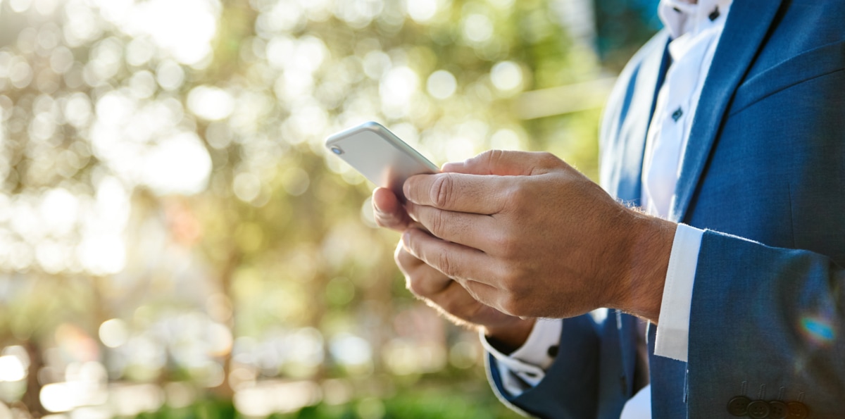 Mann im Anzug nimmt per Mobiltelefon Kontakt zum VDIV Deutschland auf.